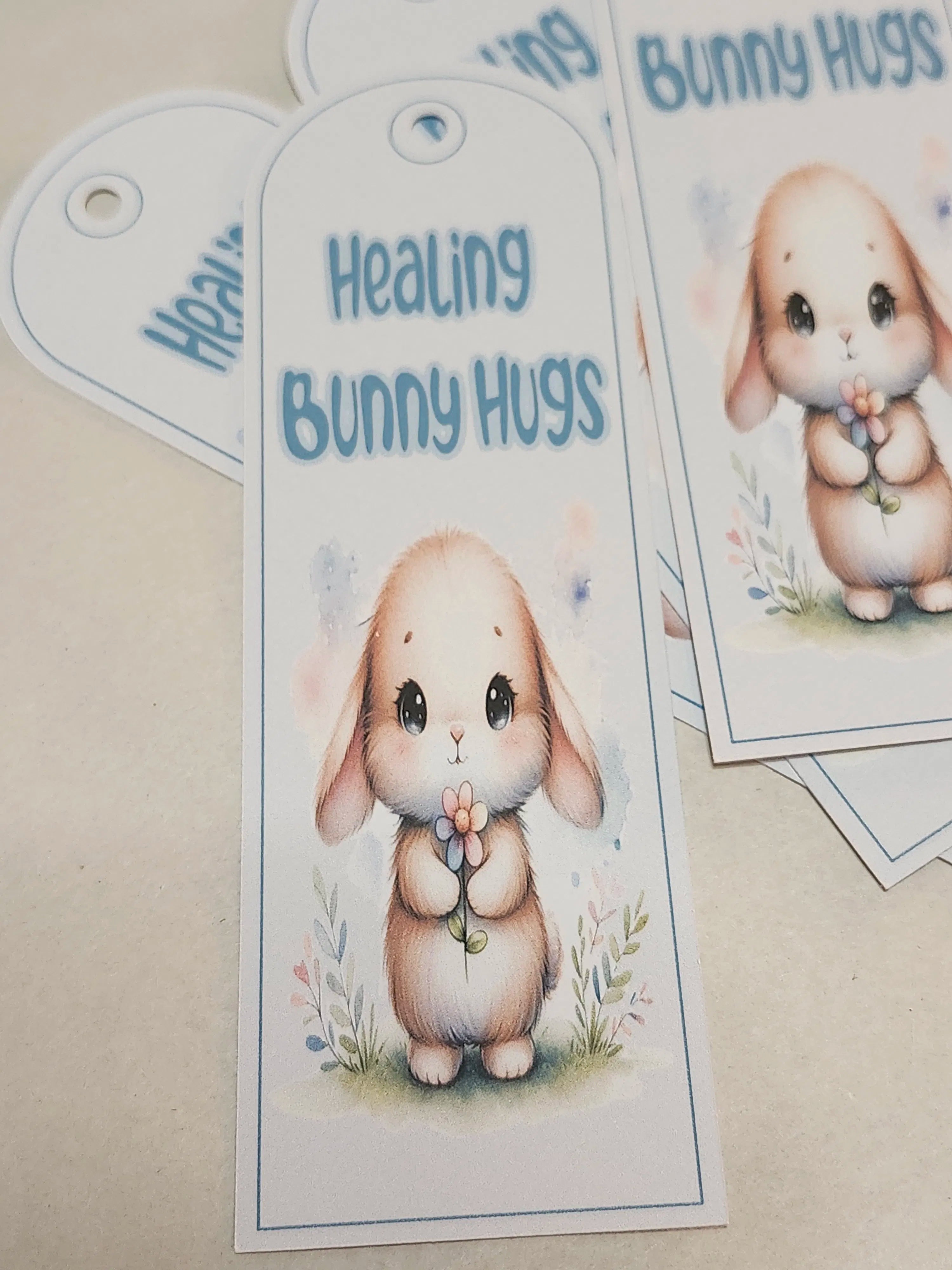 Bookmark with a cute bunny holding flowers and 'Healing Bunny Hugs' text on a beige background.