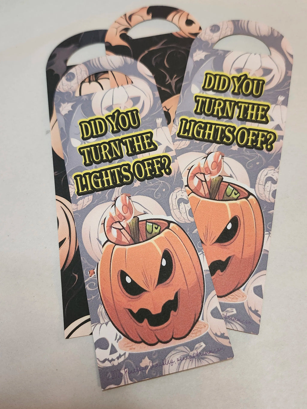Halloween-themed bookmarks with pumpkins and text on a light gray background