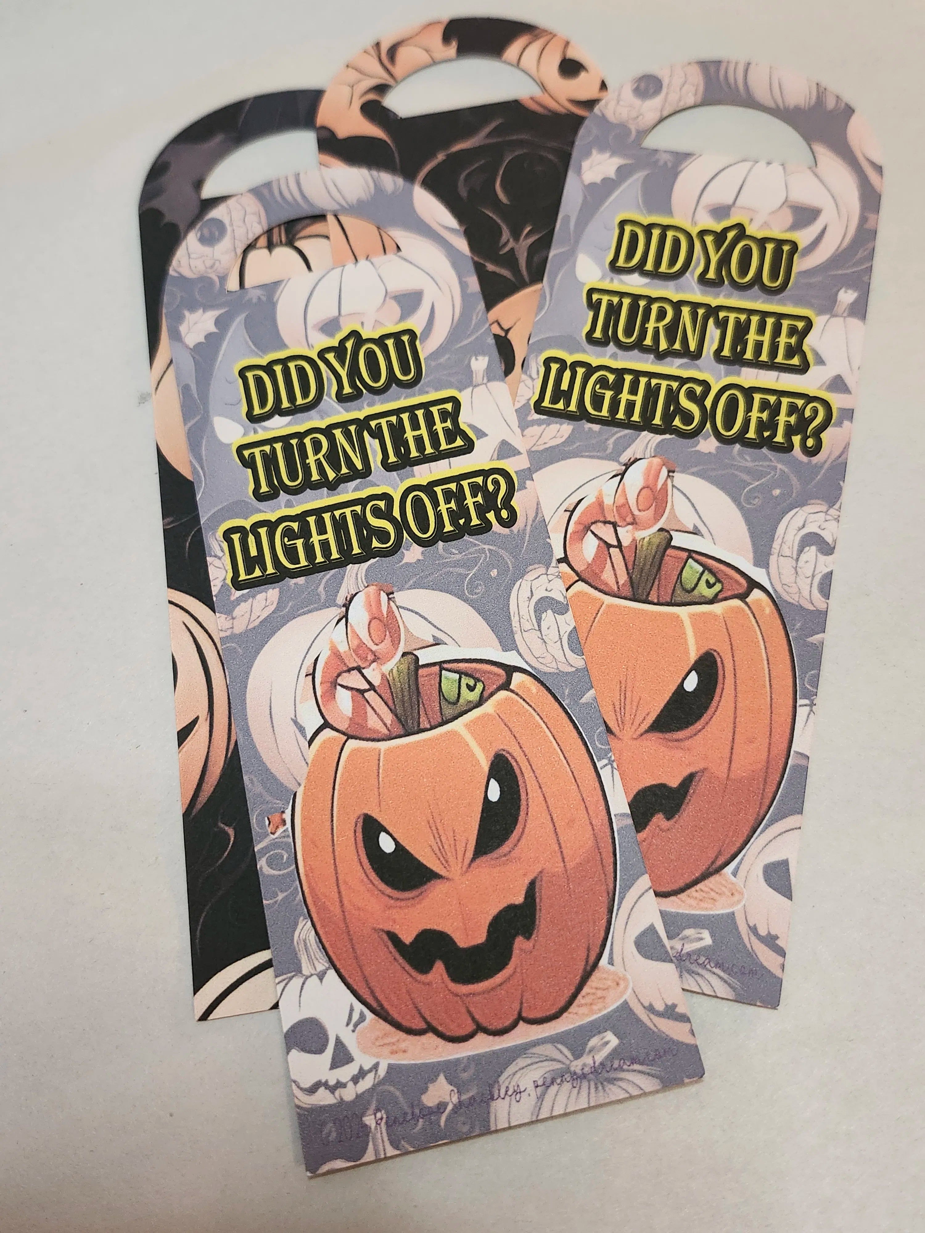 Halloween-themed bookmarks with pumpkins and text on a light gray background