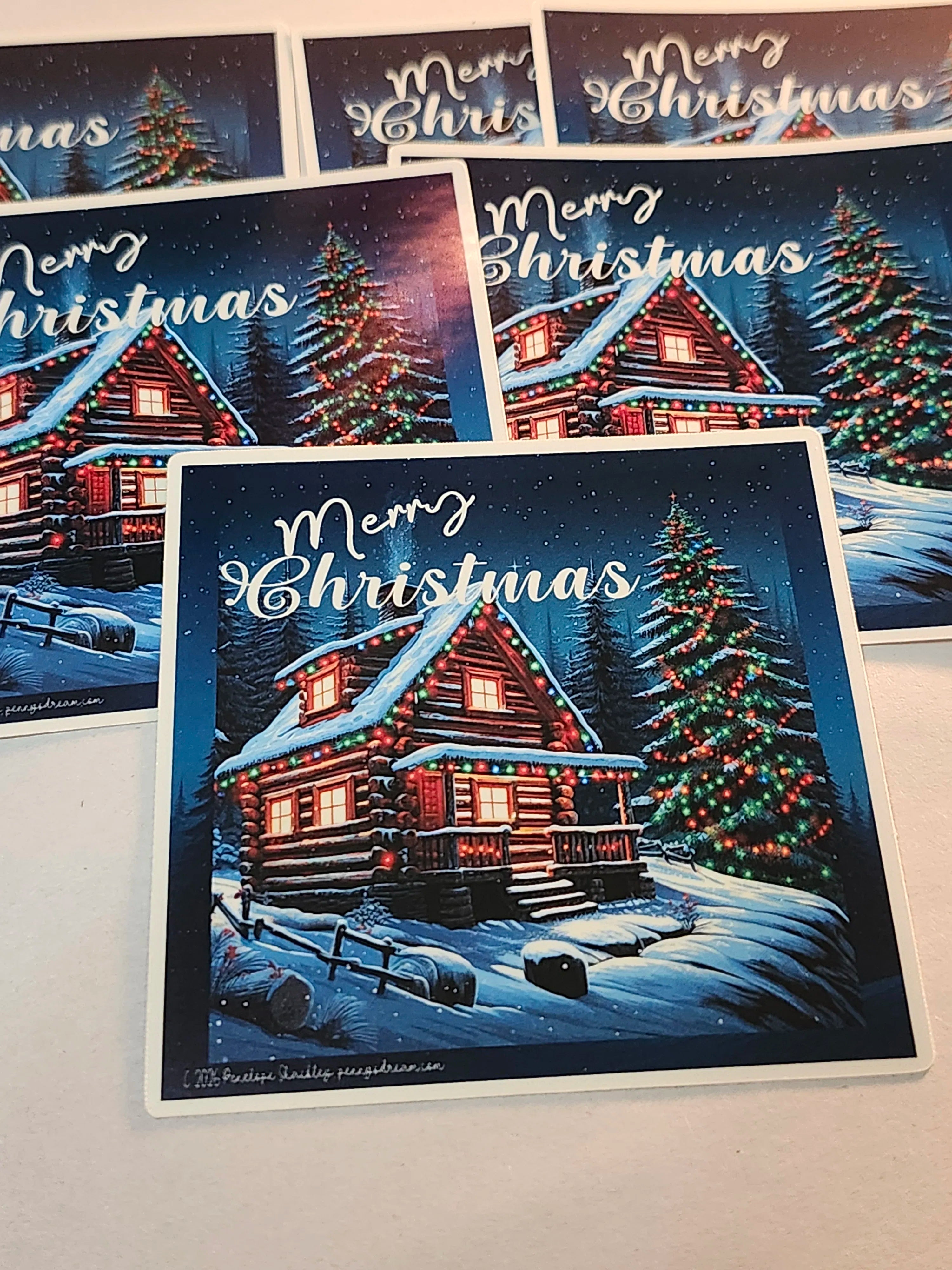 Collection of Christmas stickers with snowy scenes, cabins, and trees.