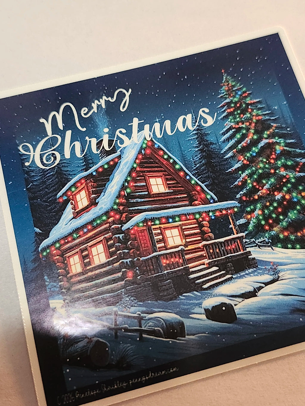 Christmas sticker with a snowy cabin and festive trees on a blue background