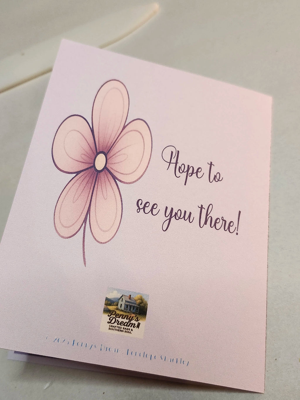 Card with a flower design and text 'Hope to see you there!' on a light background