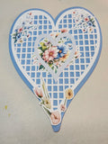 Heart-shaped decorative item with floral designs on a beige background