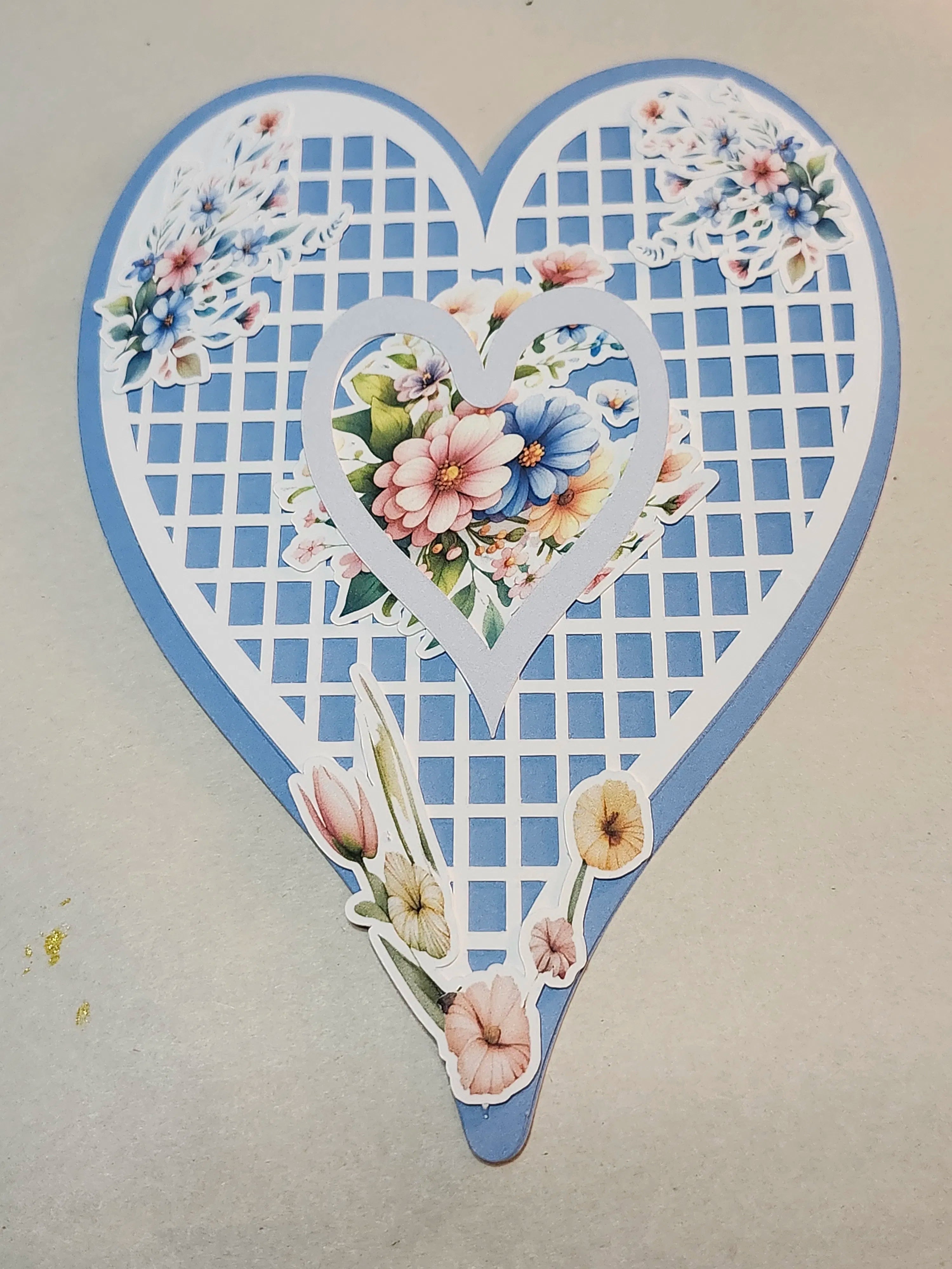 Heart-shaped decorative item with floral designs on a beige background