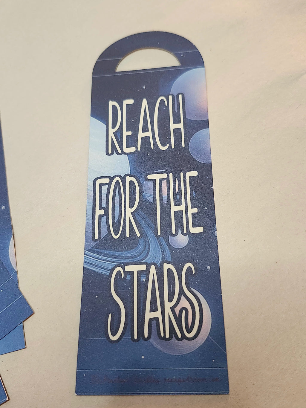 Decorative bookmark with 'Reach for the Stars' text on a blue background