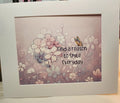 A square framed art print featuring a pastel floral design with the text 'Find a reason to smile everyday' and a small butterfly, set in a wide white frame.