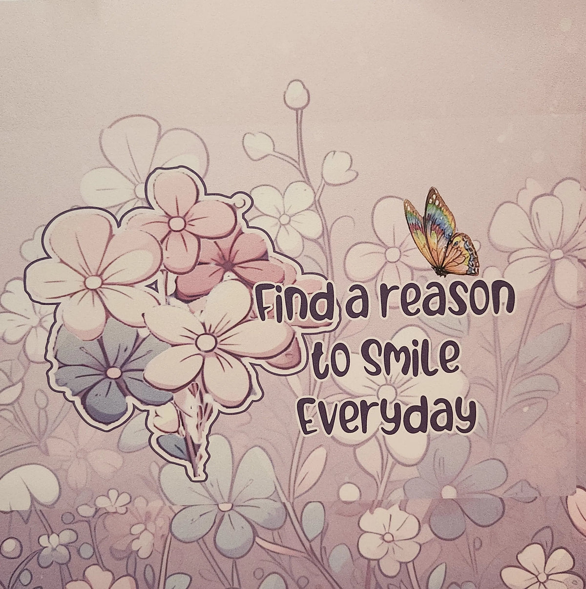 A square graphic print with the motivational quote 'Find a reason to smile everyday' in dark purple lettering, surrounded by a pastel floral illustration in pink, lavender, and white, with a small butterfly on the right side.