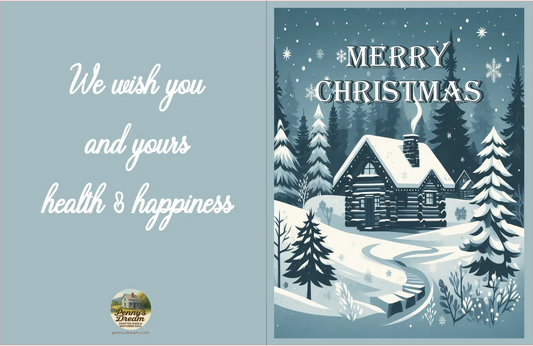 Christmas card with snowy cabin and trees, featuring a blue background and festive text.