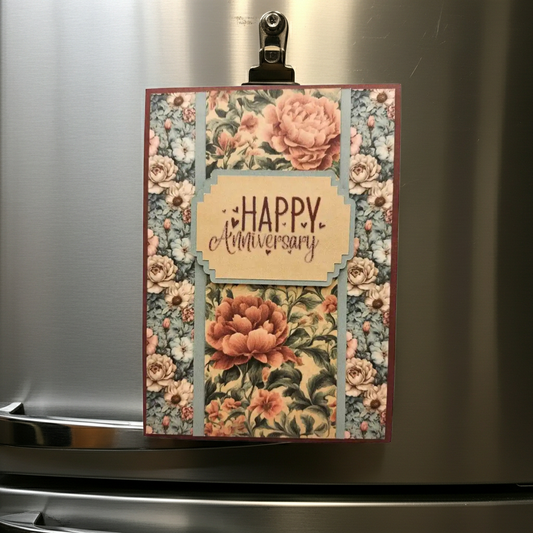 Floral card with 'Happy Anniversary' text on a metallic surface